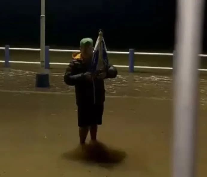 Un hombre recorre la zona de la crecida en Itatí con la imagen de la Virgen entre sus manos